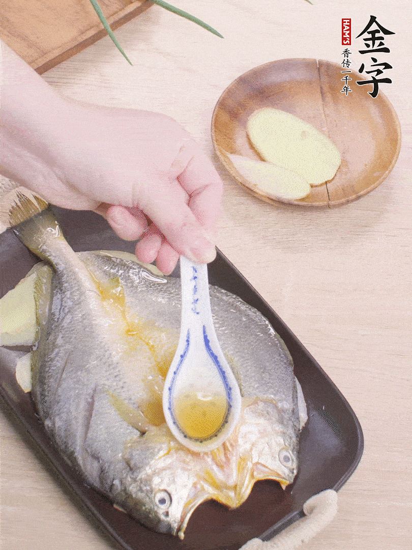盤(pán)底鋪姜片，放黃魚(yú)，淋2勺料酒。